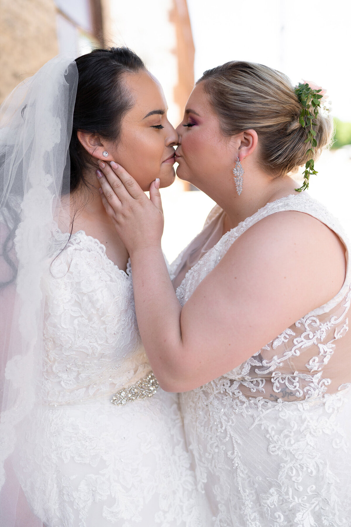 Lesbian couple kisses on wedding day.