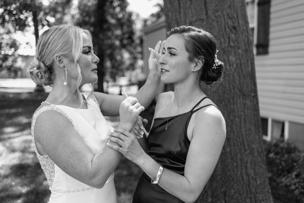 bride with sister holding back tears