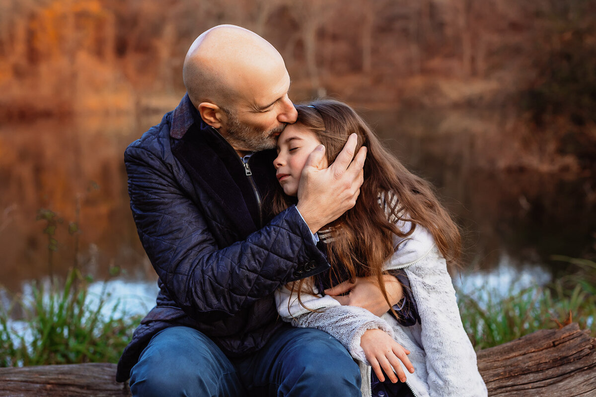 dad kissing daughters head during long island family photos