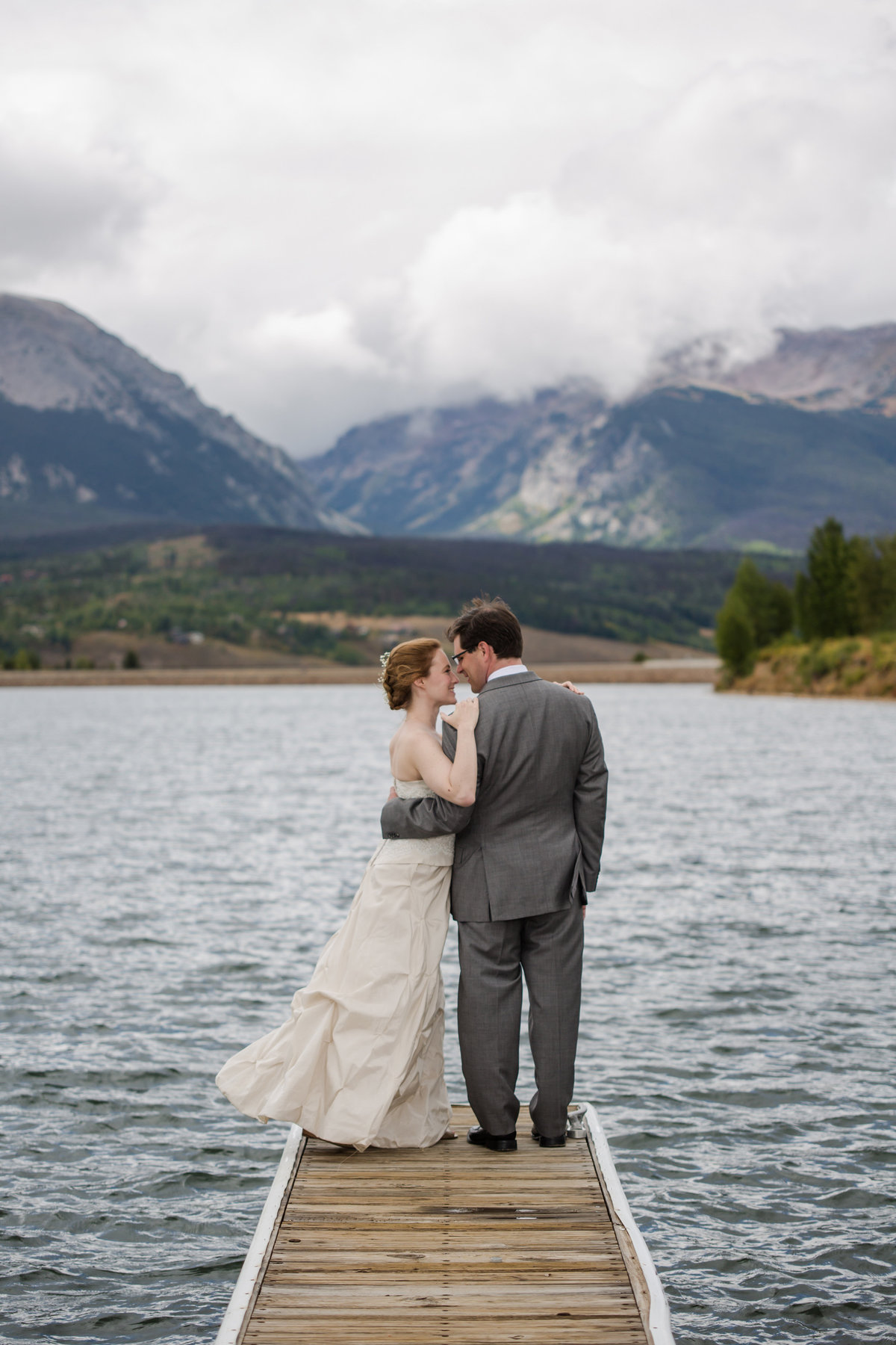 couple on dock on lake with mountains