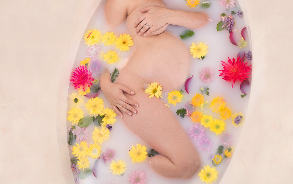 Maternity milk bath photoshoot with colorful flowers in Franklin Tennessee photography studio