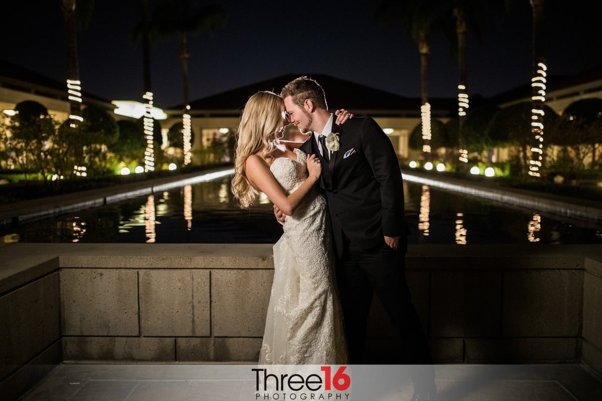 Tender moment at night between the Bride and Groom in front of the reflecting pool at the Richard Nixon Library