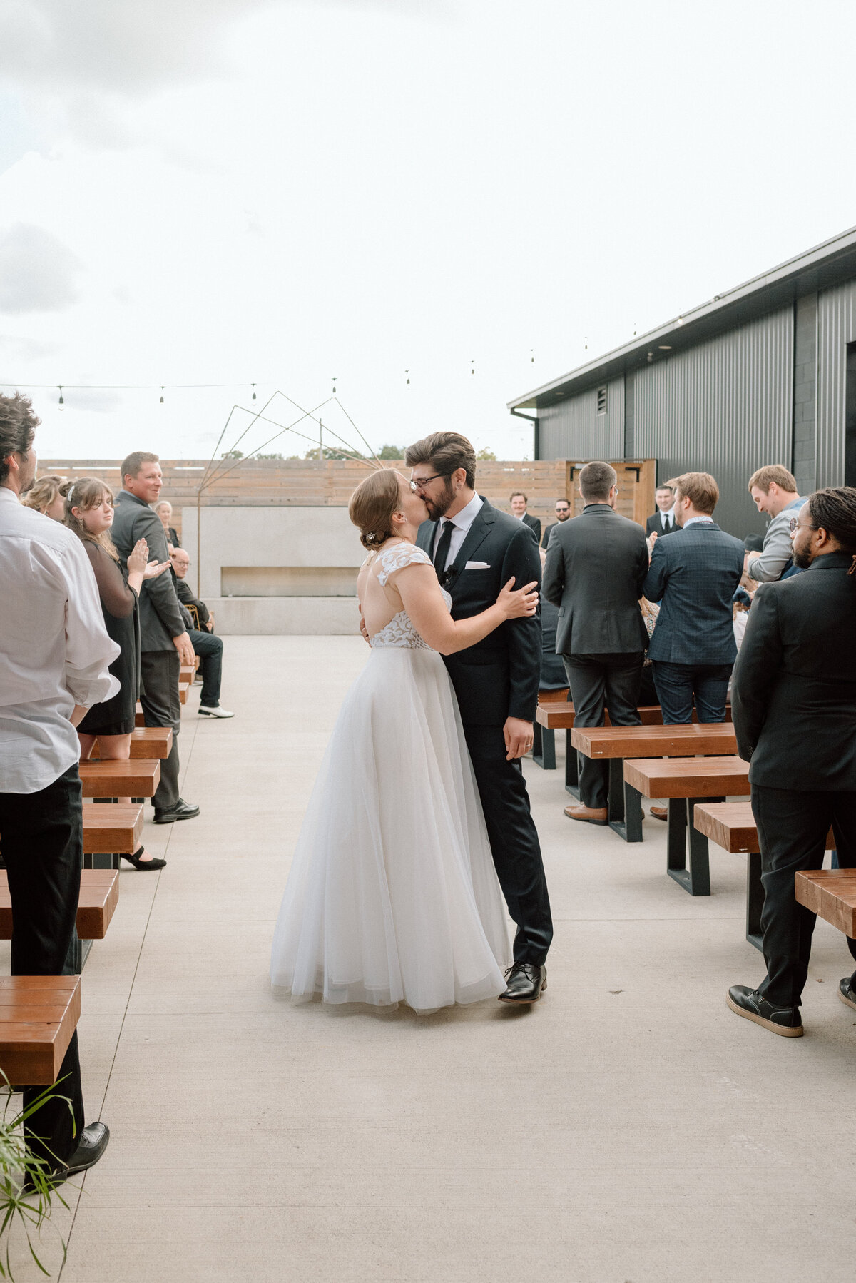 couple kisses one more time at end of the aisle