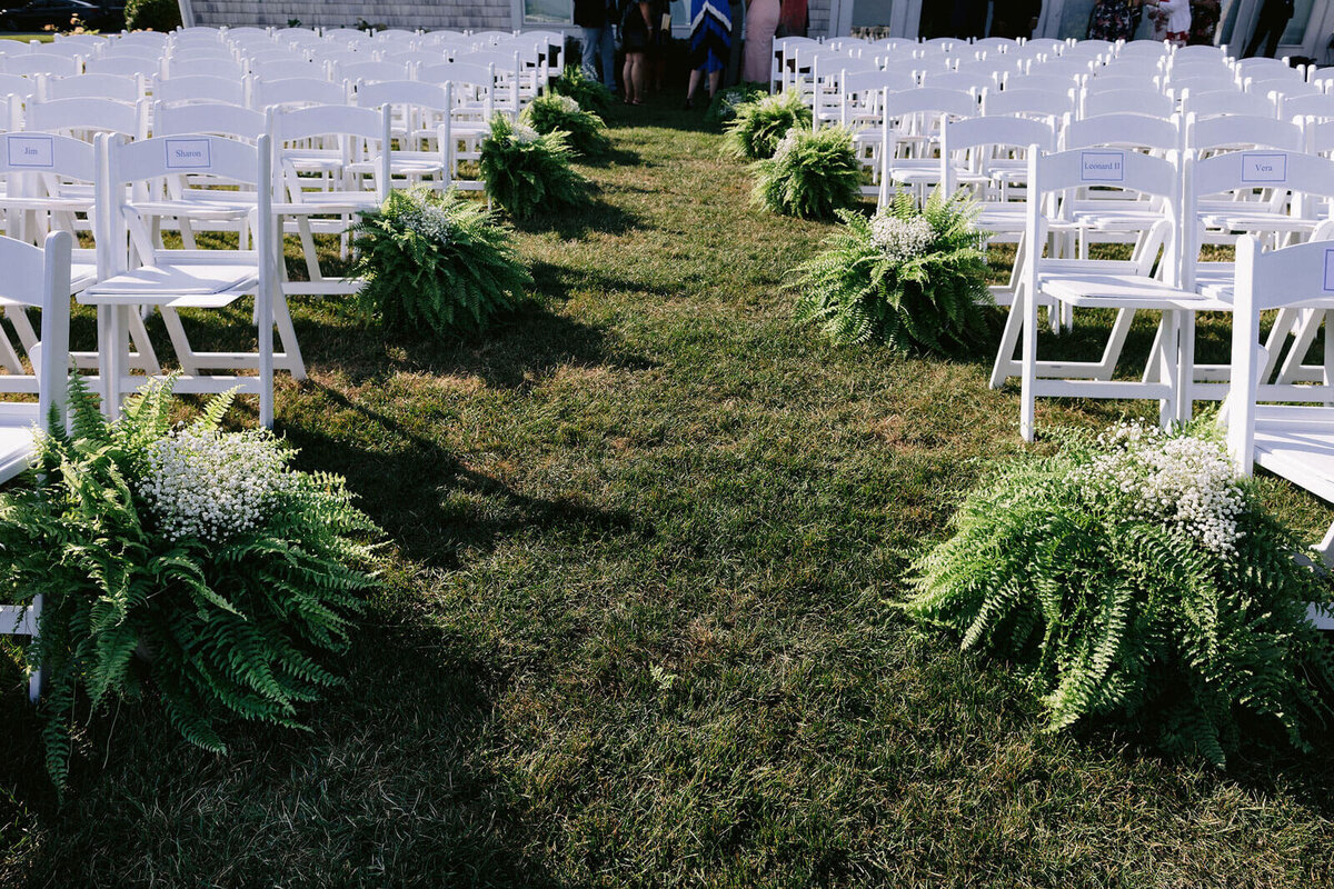 A wedding aisle with white chairs at Wianno Club, Cape Cod, Osterville, MA.
