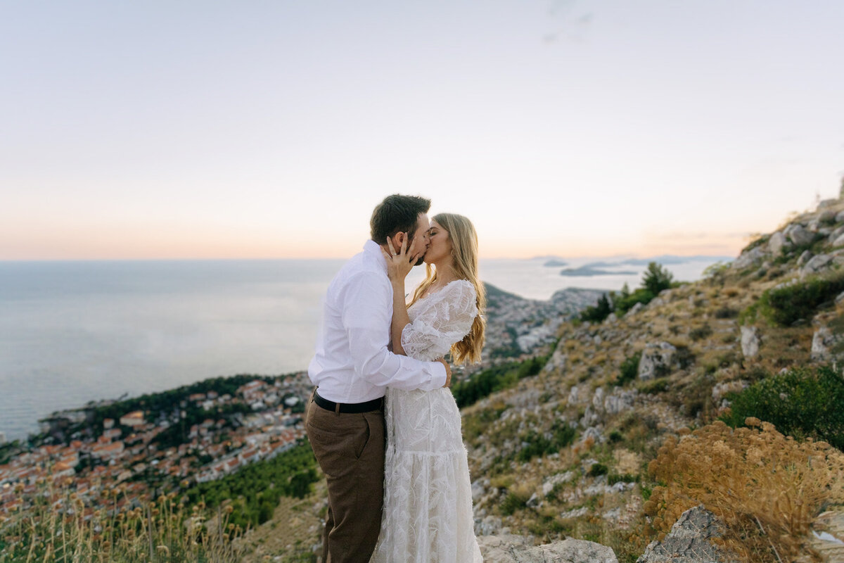 bride and groom honeymoon in croatia kissing on top of srd hill in dubrovnik croatia
