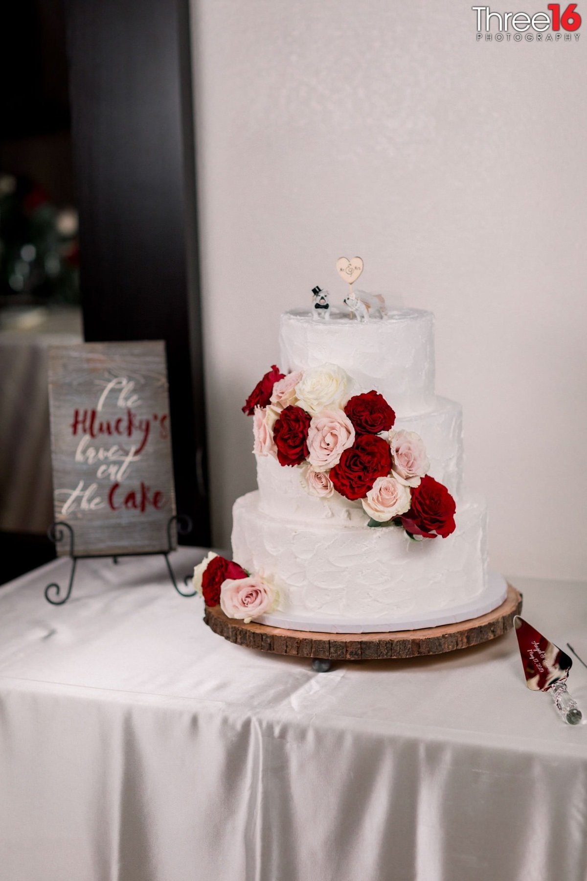 Beautiful three-tiered wedding cake draped with flowers
