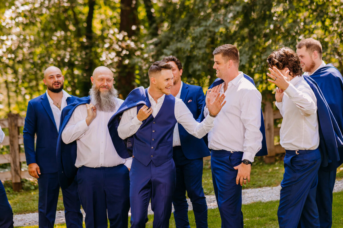 Photo of a groom shaking hands with his groomsmen and cheering