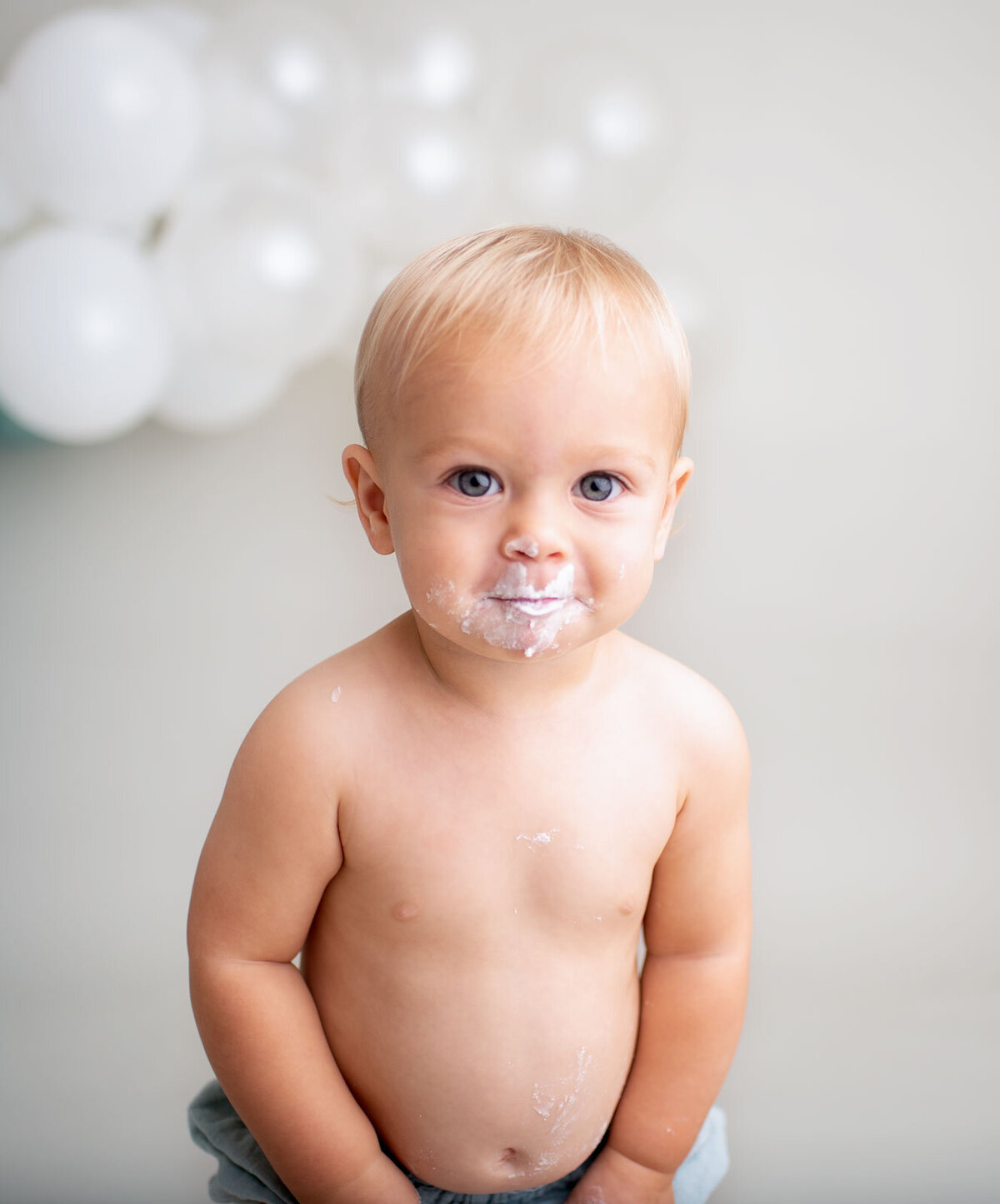 smiling baby with cake on his face by saint louis cake smash photographer