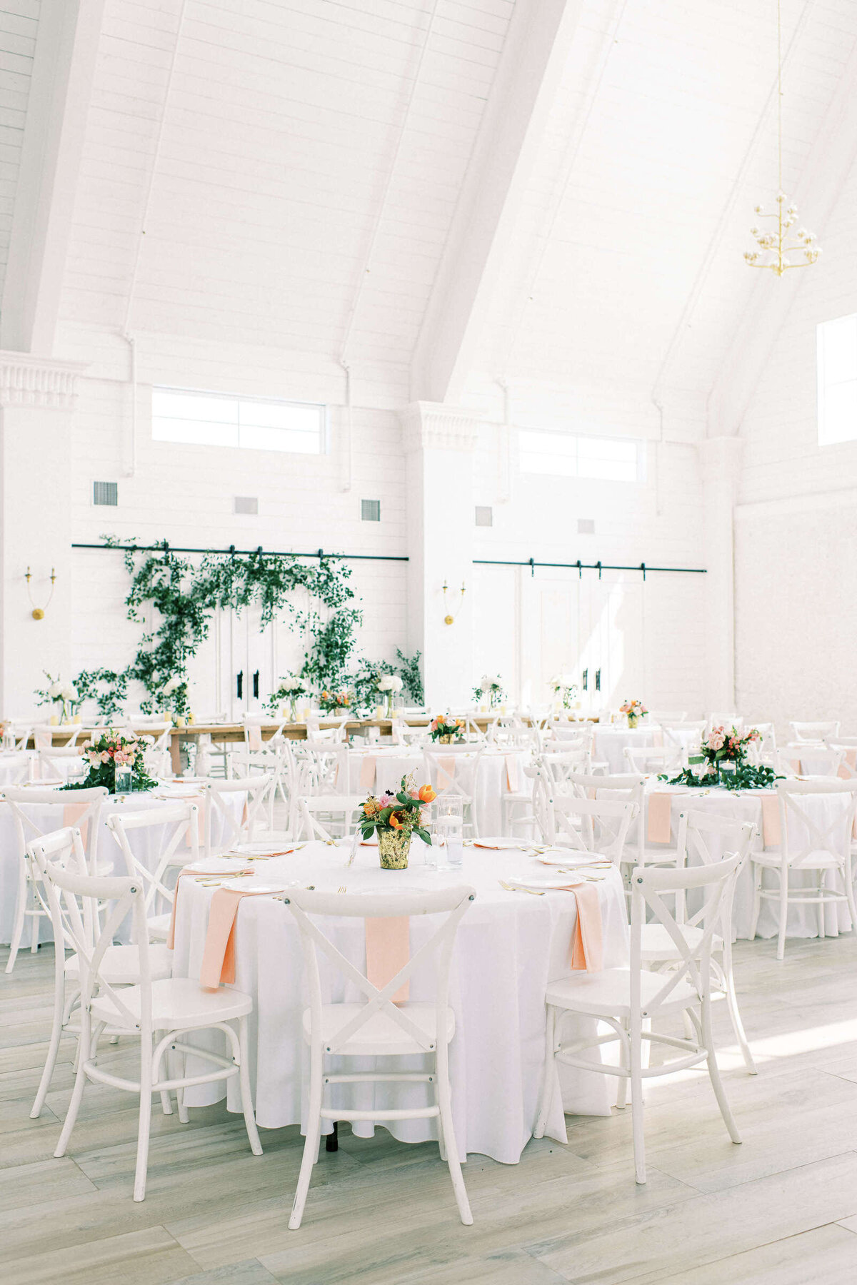 The Nest at Ruth Farms wedding reception hall with blush napkins and greenery