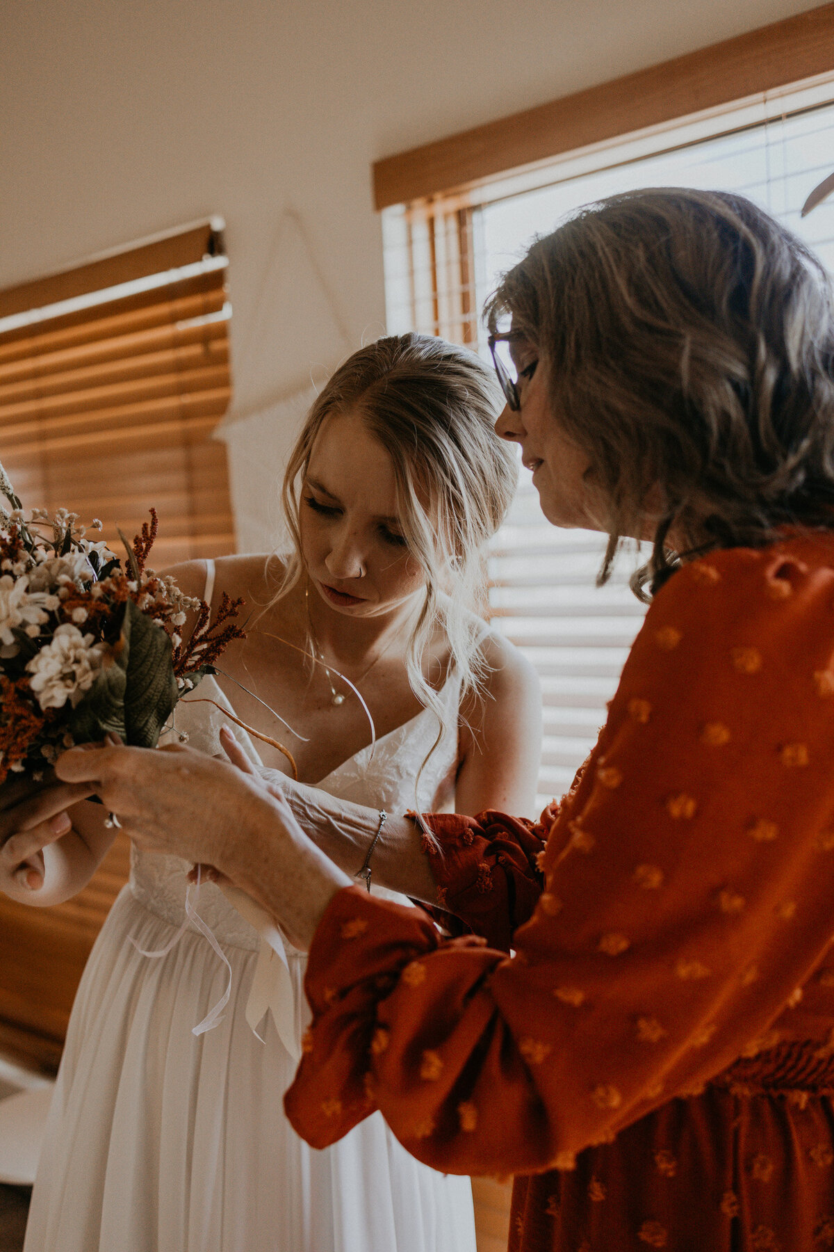 bride and mom putting together DIY bouquet
