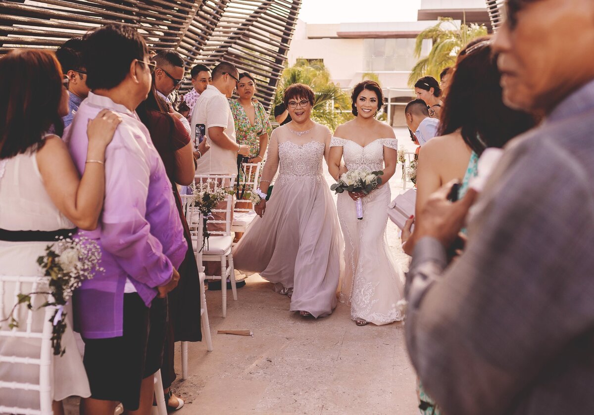 Bride walking down aisle with mother at wedding in Cancun
