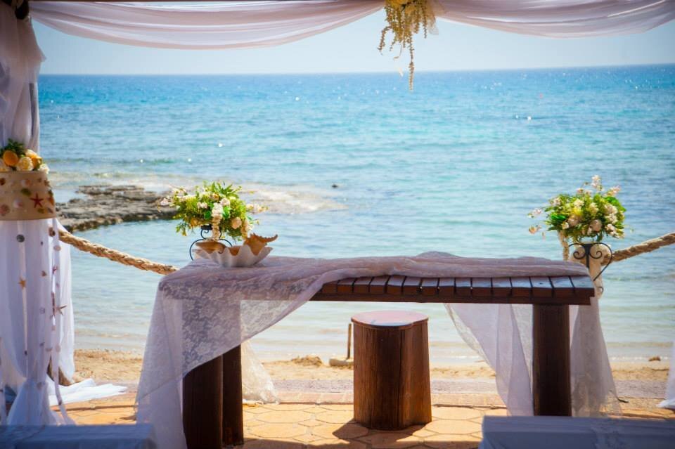 Rustic style wooden ceremony table in front of a clear blue sea