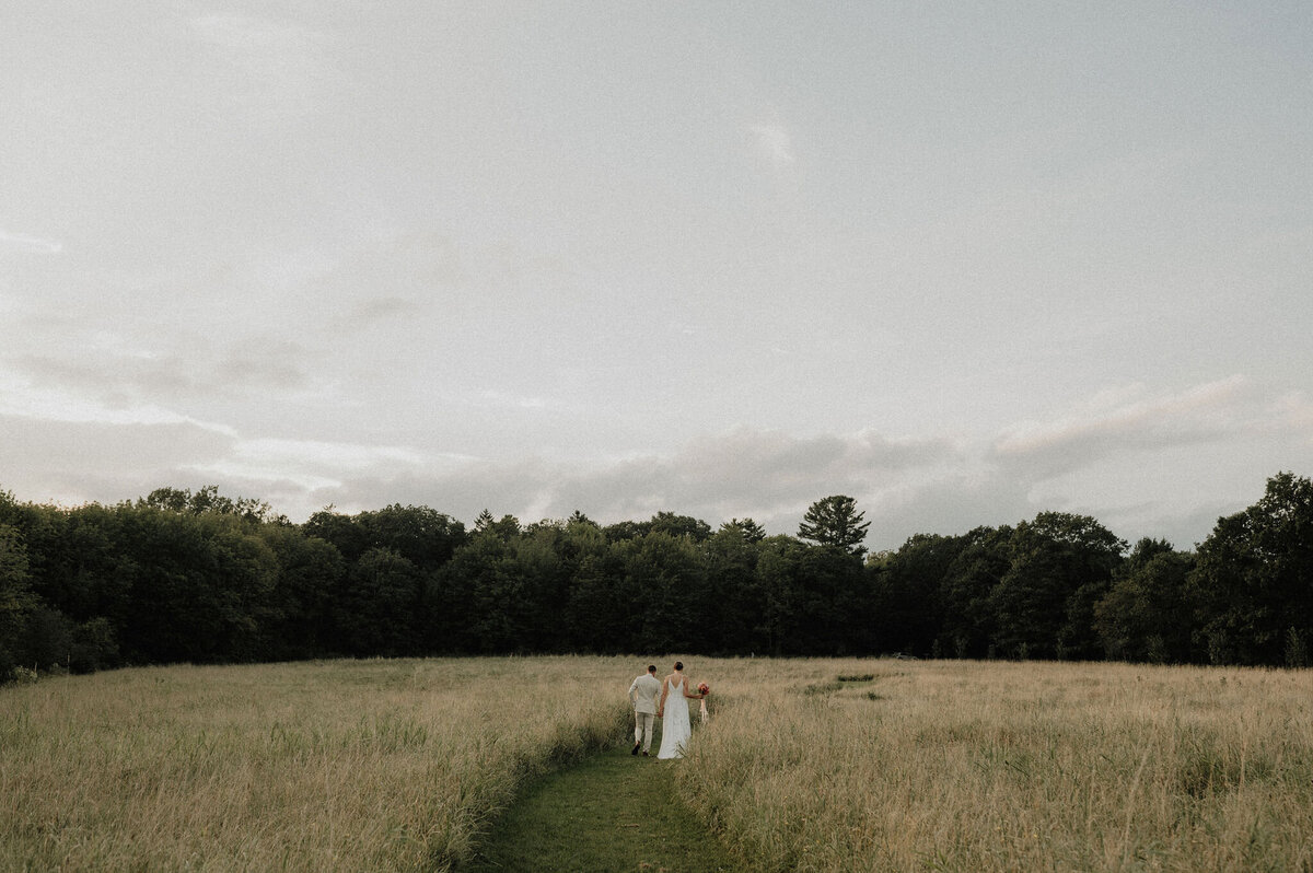 New England couple in field holding bouquet