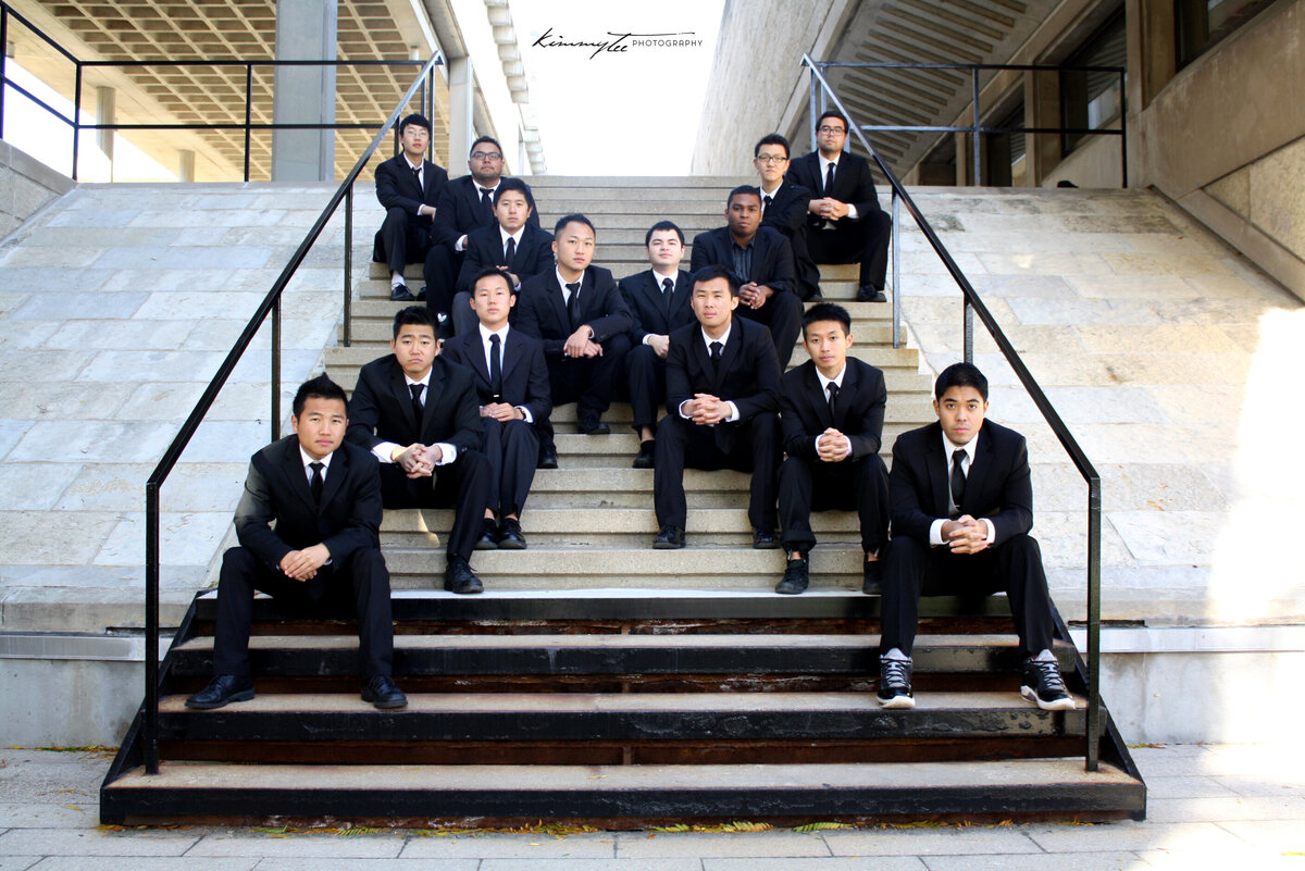 Chi Sigma Tau fraternity brothers in suits sitting in X formation on stairs