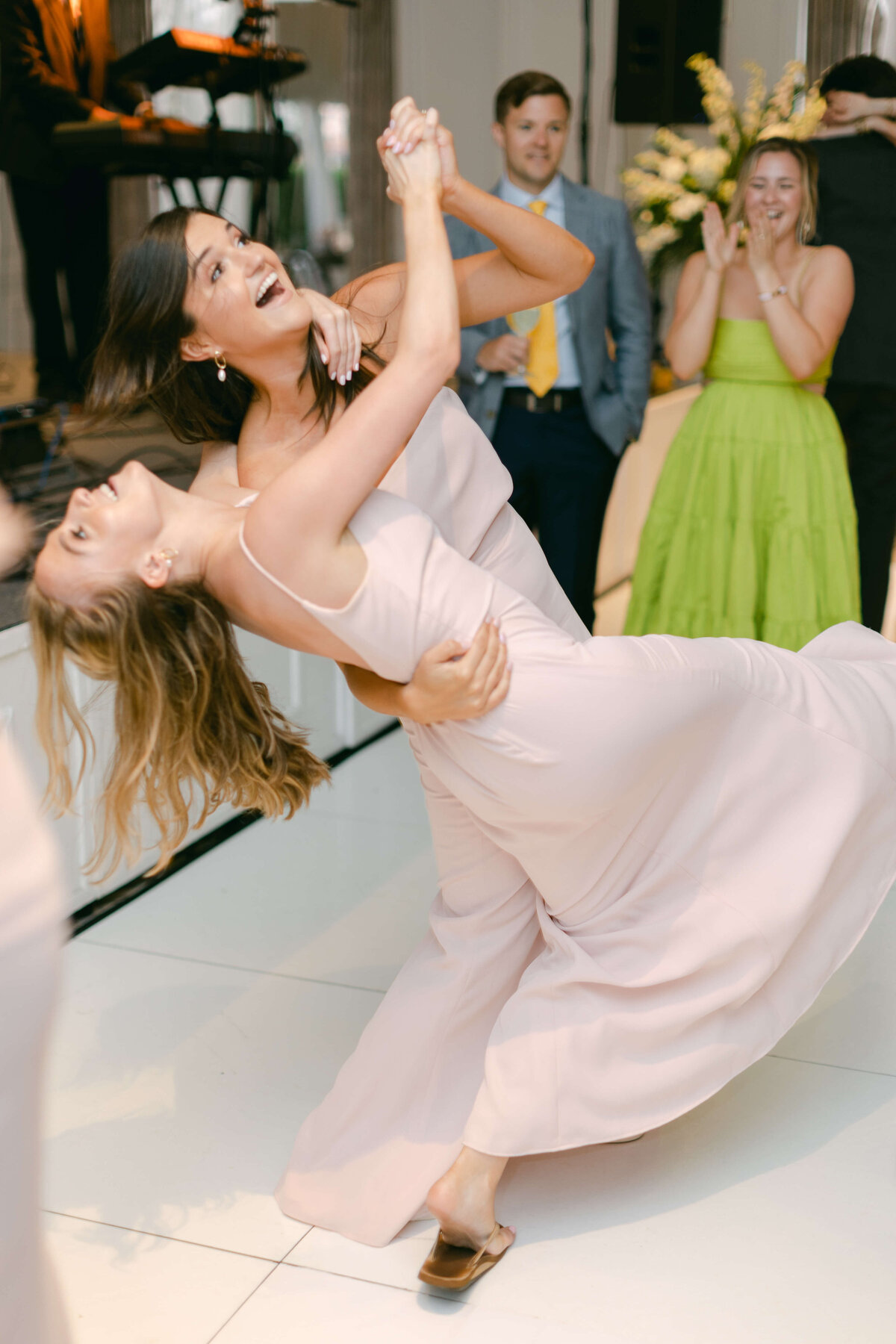 Two wedding guests dance happily.