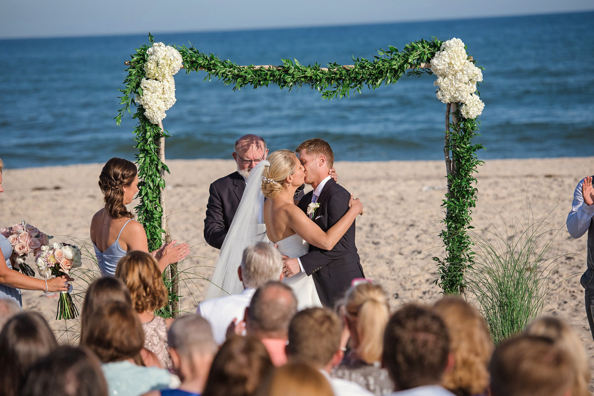 First kiss as husband and wife during a beach ceremony
