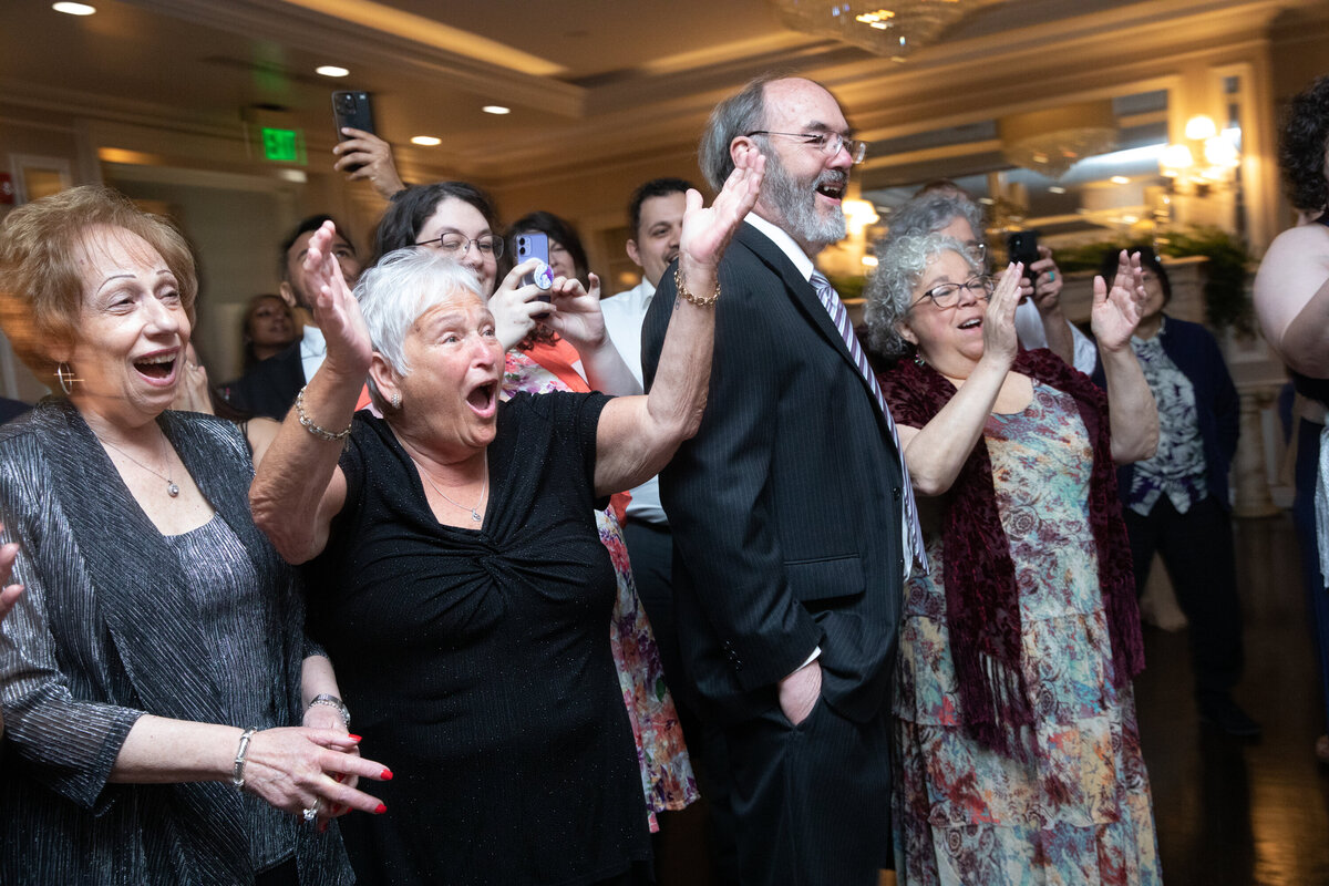 Elderly wedding guests cheer during the cake cutting Briarcliff Manor wedding photographer Milestone Images