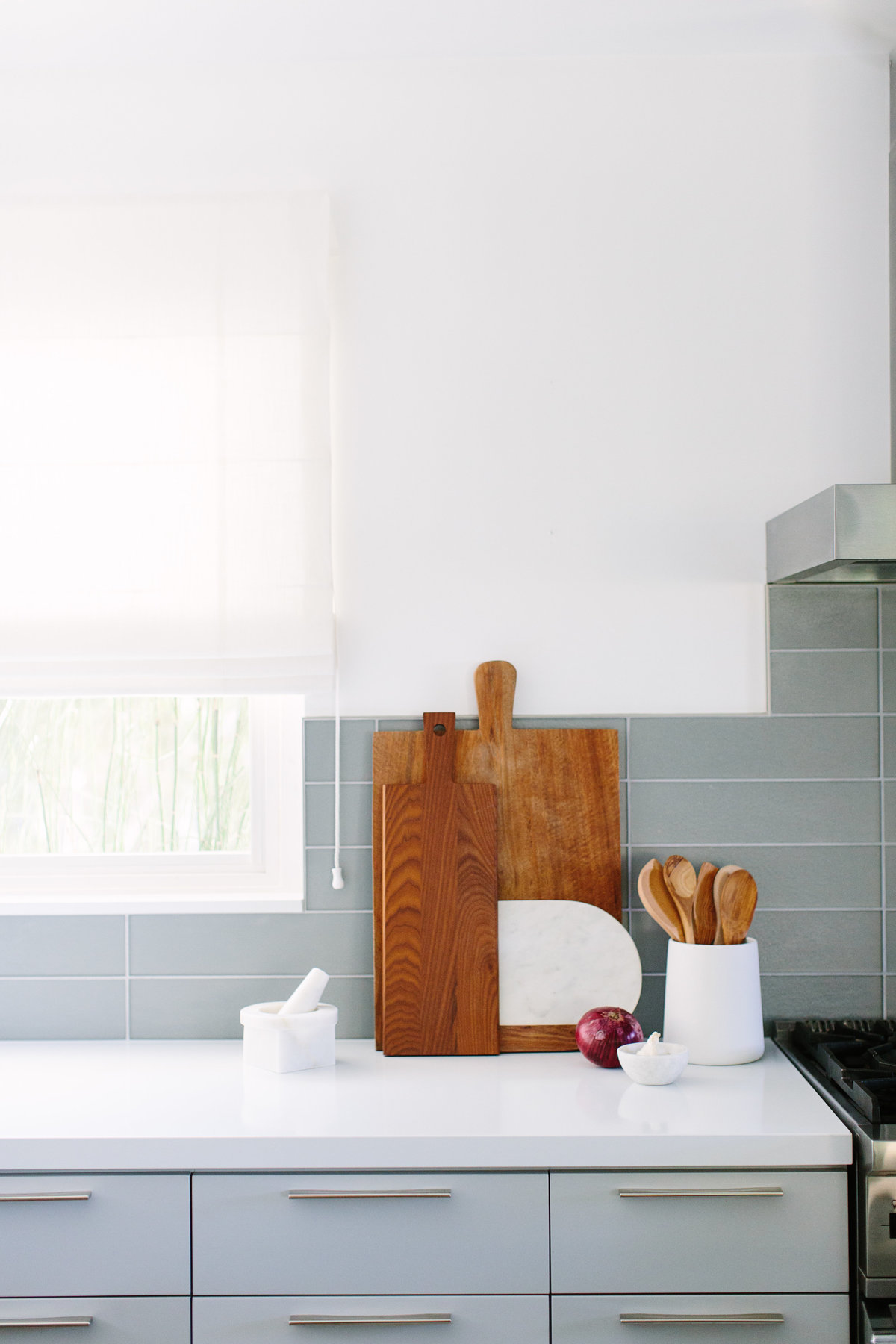 Kitchen with glass backsplash and light gray lowers