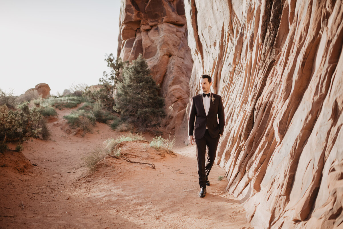Utah elopement photographer captures groom walking during bridal portraits