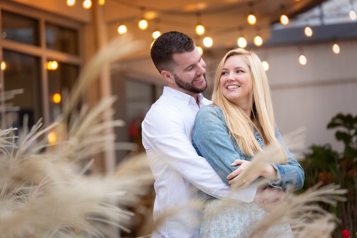 engaged-couple-smiling-back-hug-romantic