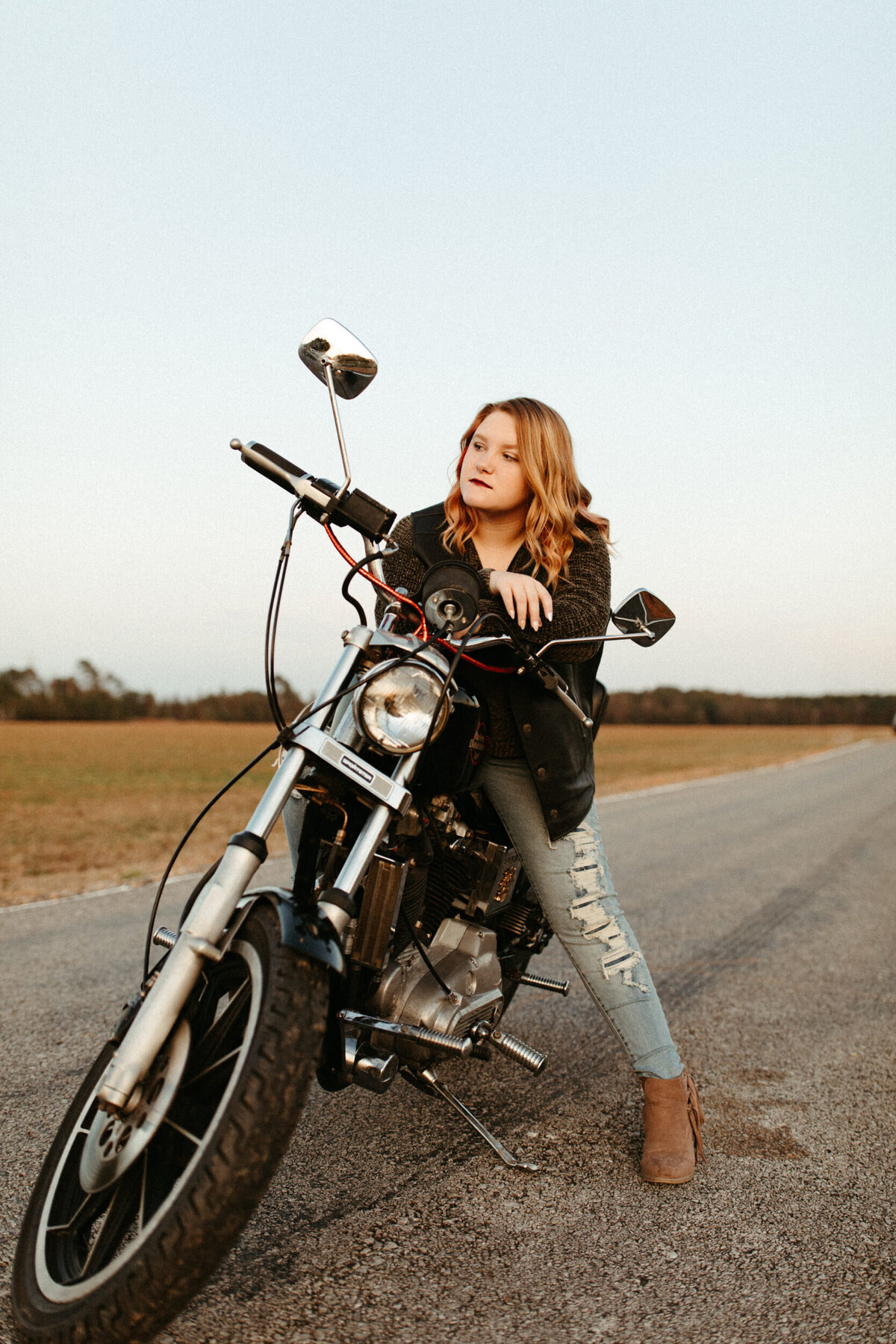 High school senior posing on a motorcycle in the road