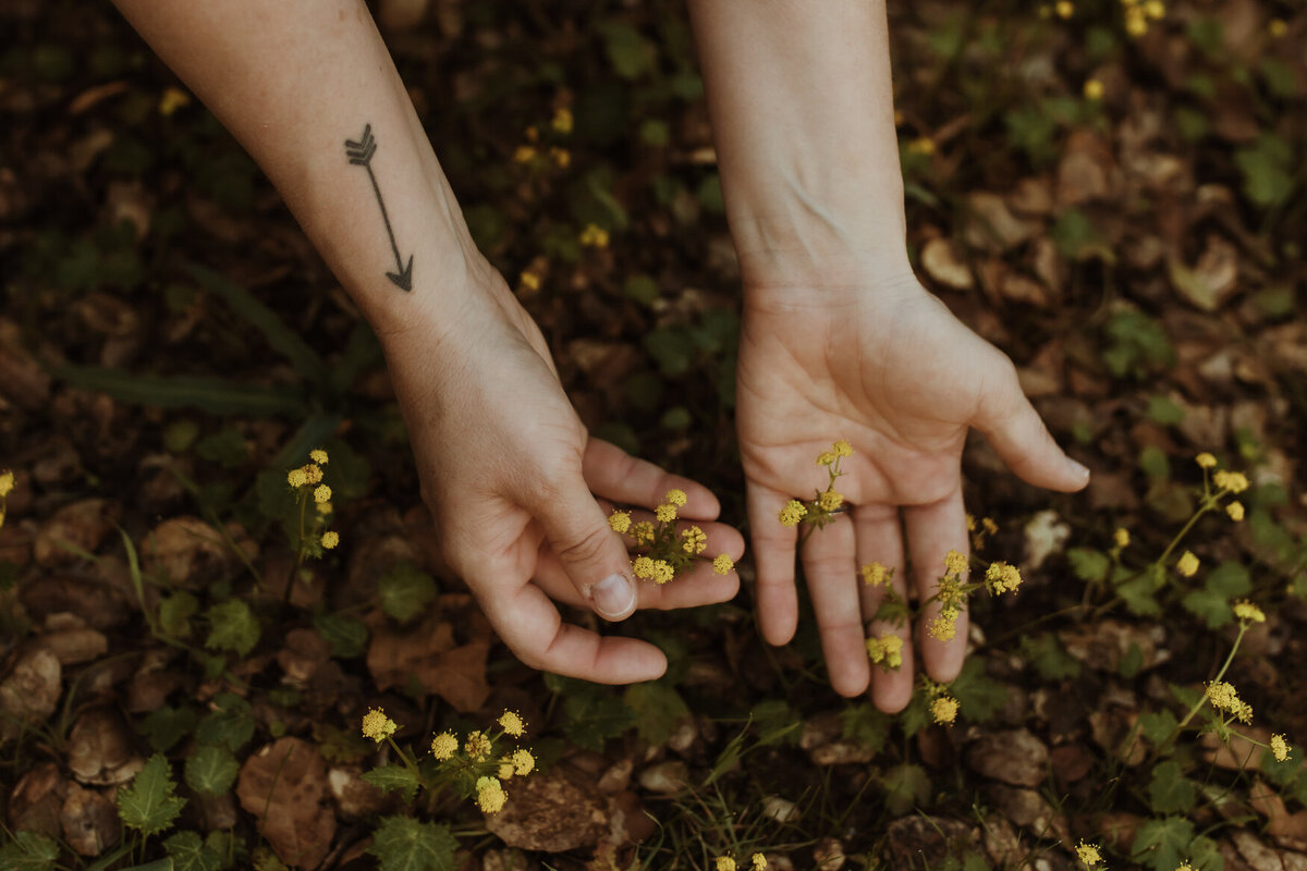Storytelling branding content image for bay area businesswoman with tattoos holding yellow flowers