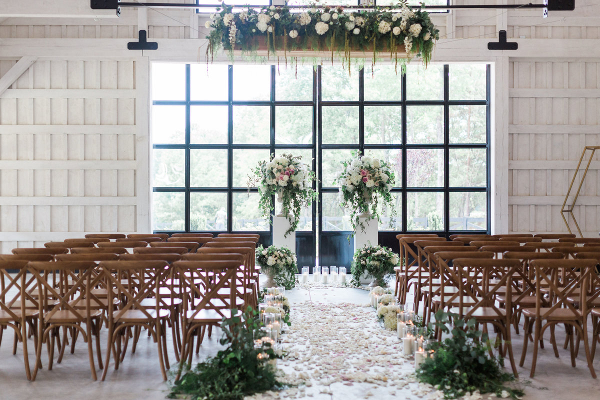 Event design Ceremony decor with white columns, 2 urns and lots of greenery
