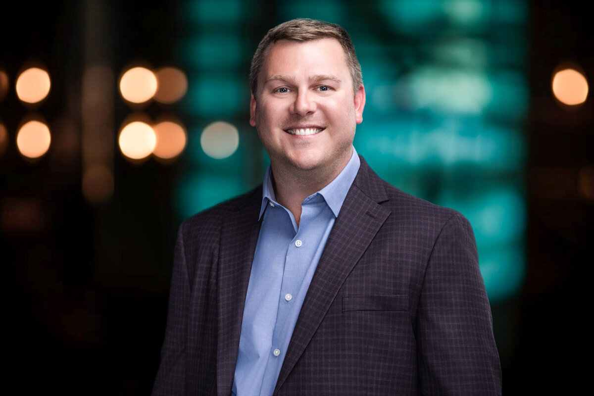 This headshot of Daniel Luehrmann is a prime example of professional personal branding photography, expertly captured to showcase a confident and approachable demeanor. Taken in a studio setting with Cincinnati's top natural light and backdrop options, this headshot is designed to elevate his personal brand, making it ideal for corporate use, LinkedIn profiles, or business websites. With the vibrant backdrop complementing his formal attire, the portrait highlights both professionalism and warmth, key traits for leaders in today's business world.  A personalized headshot like this can significantly enhance online presence, ensuring that your first impression resonates with clients and colleagues alike. If you're looking for a professional headshot in Cincinnati that captures your essence and fits your brand, our studio offers a seamless experience with same-day image selection, expert posing guidance, and a variety of backdrop options.