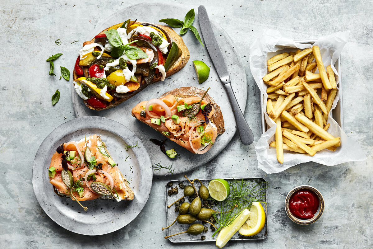 A few different types of bruschetta with a small plate of fries next to it.