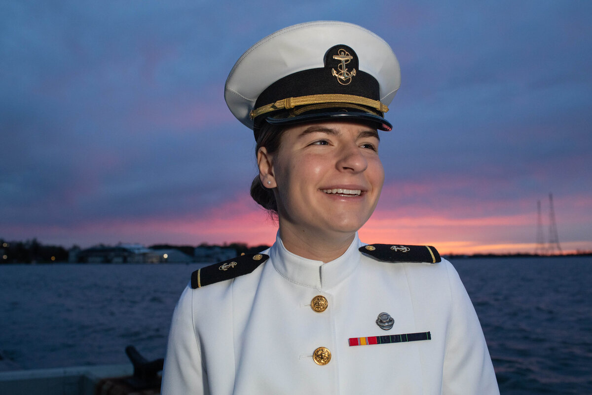 Beautiful, smiling navy officer in white uniform at sunrise in Annapolis Maryland.