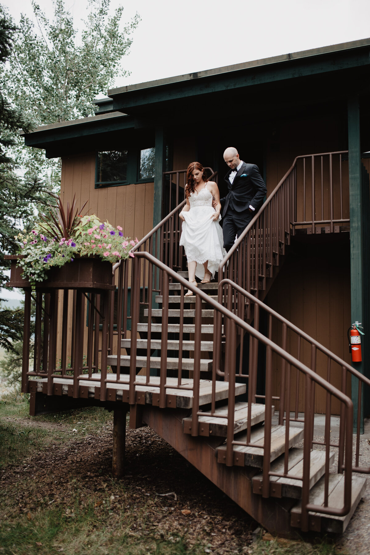 Jackson Hole Photographers capture bride and groom walking downstairs before adventure elopement