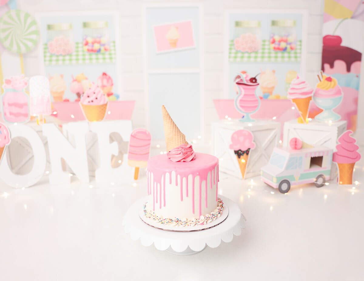 A beautifully decorated ice cream cake set up for a first birthday cake smash in Rochester, NY.