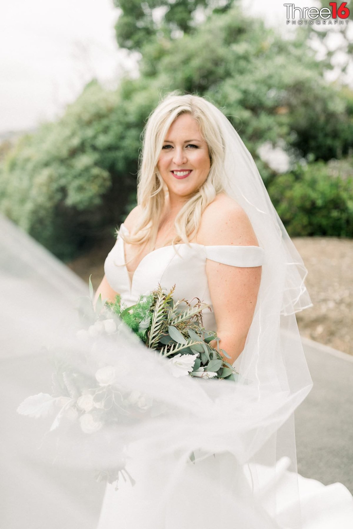 Bride poses with a big smile for wedding photographer