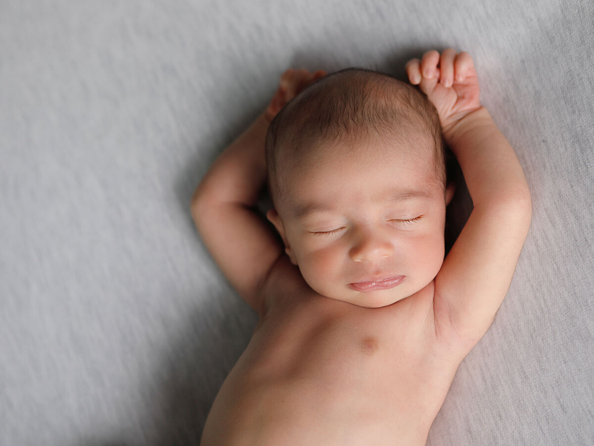 Newborn-photography-session-newborn-sleeping-on-his-back-on-grey-blanket-,-newborn-photo,-photo-taken-by-Janina-Botha-photographer-in-Oakville-Ontario