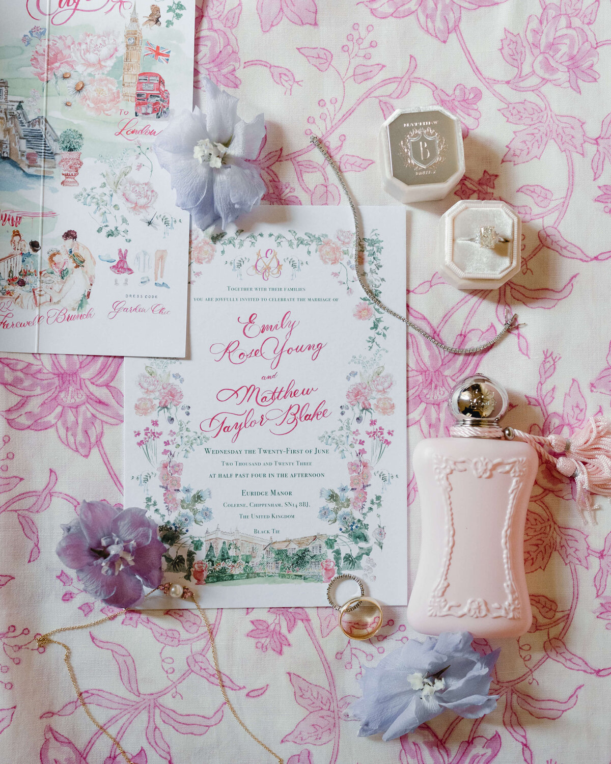 romantic illustrated pink wedding stationery flatlay on a pink and white floral pattered background decorated with flowers and luxury wedding details