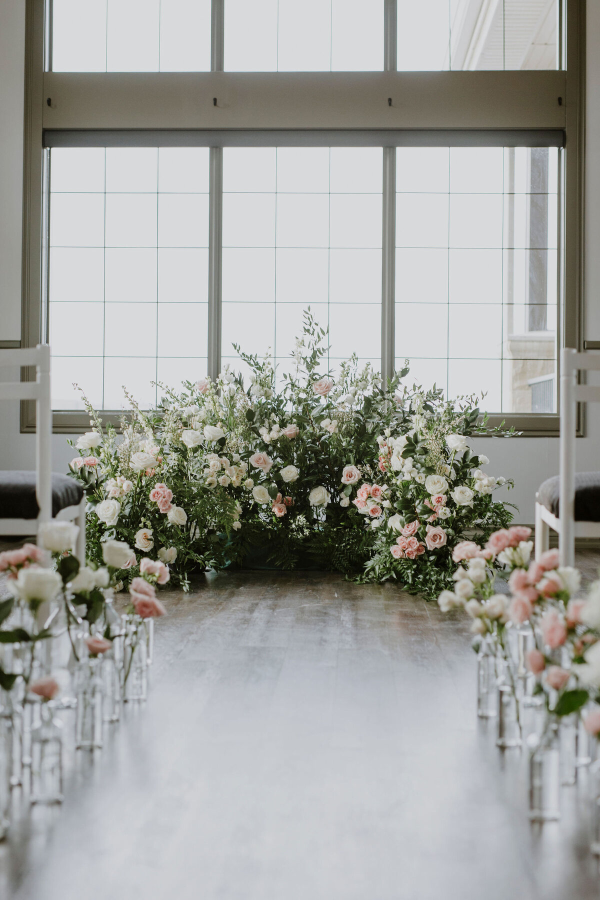 Stunning and romantic ceremony floral backdrop created by Hen & Chicks, classic Calgary, Alberta wedding florist, featured on the Brontë Bride Vendor Guide.