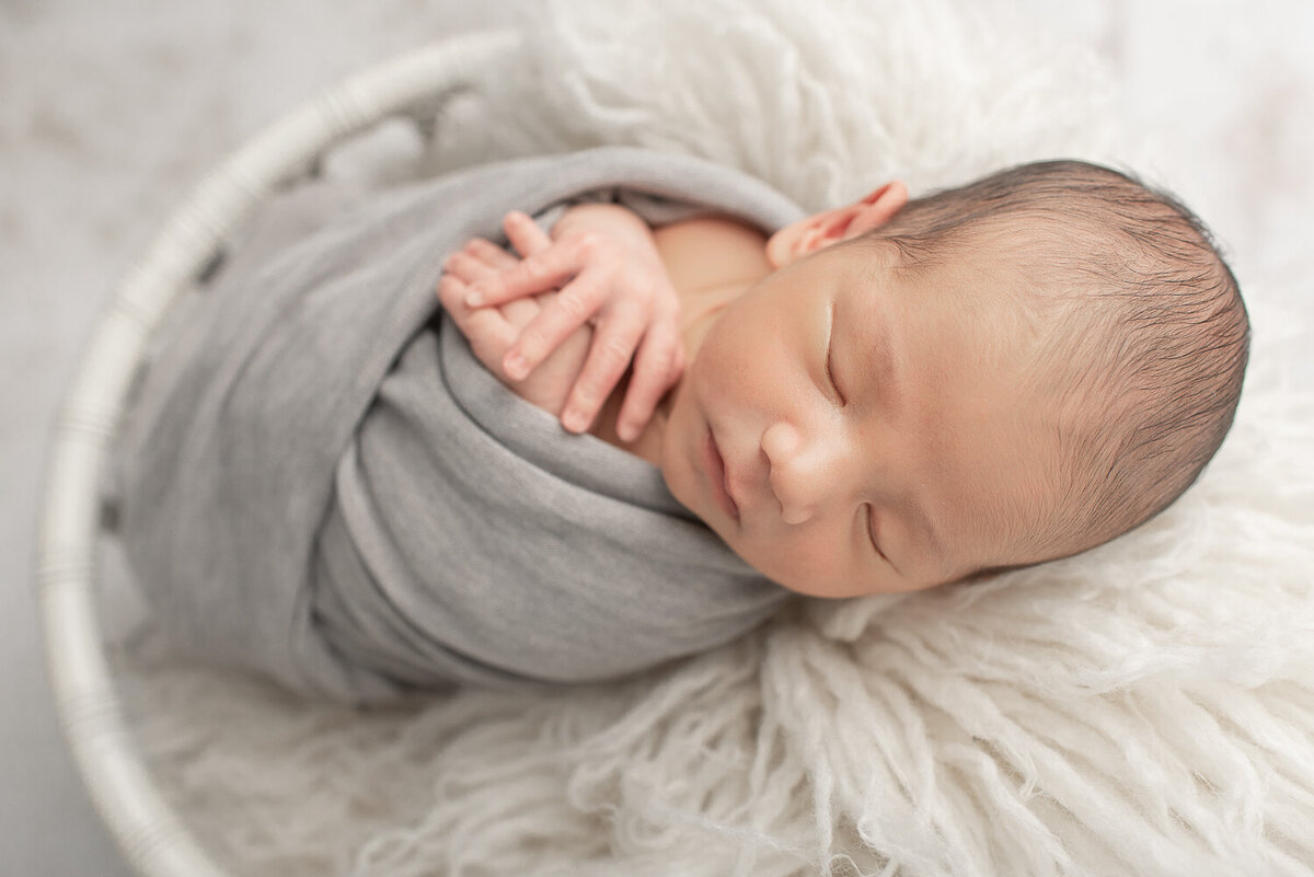 Newborn boy wrapped in gray in white crib at newborn studio session | Sharon Leger Photography | CT Newborn & Family Photographer | Canton, Connecticut