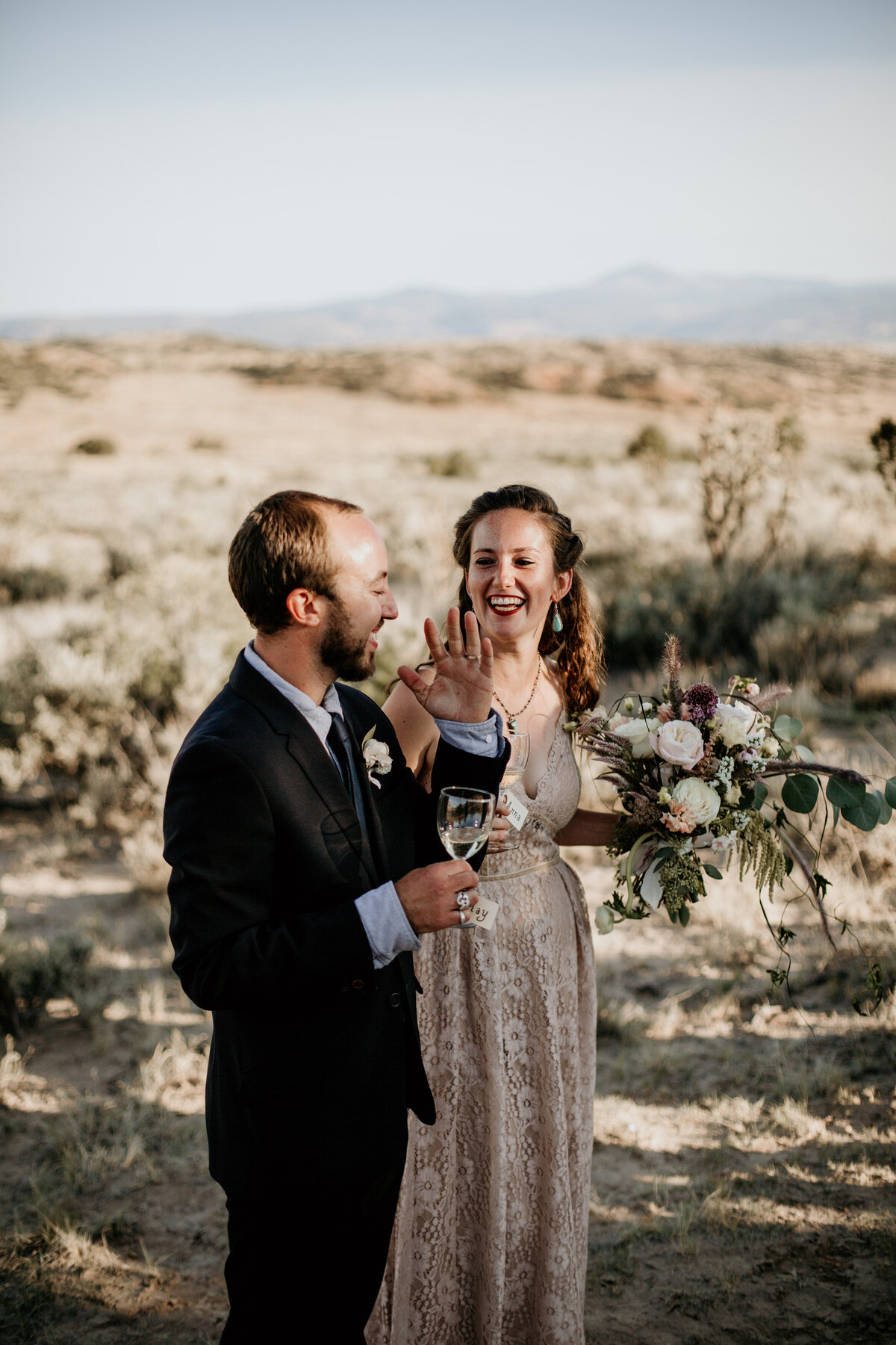 eloping couple toasting in the desert