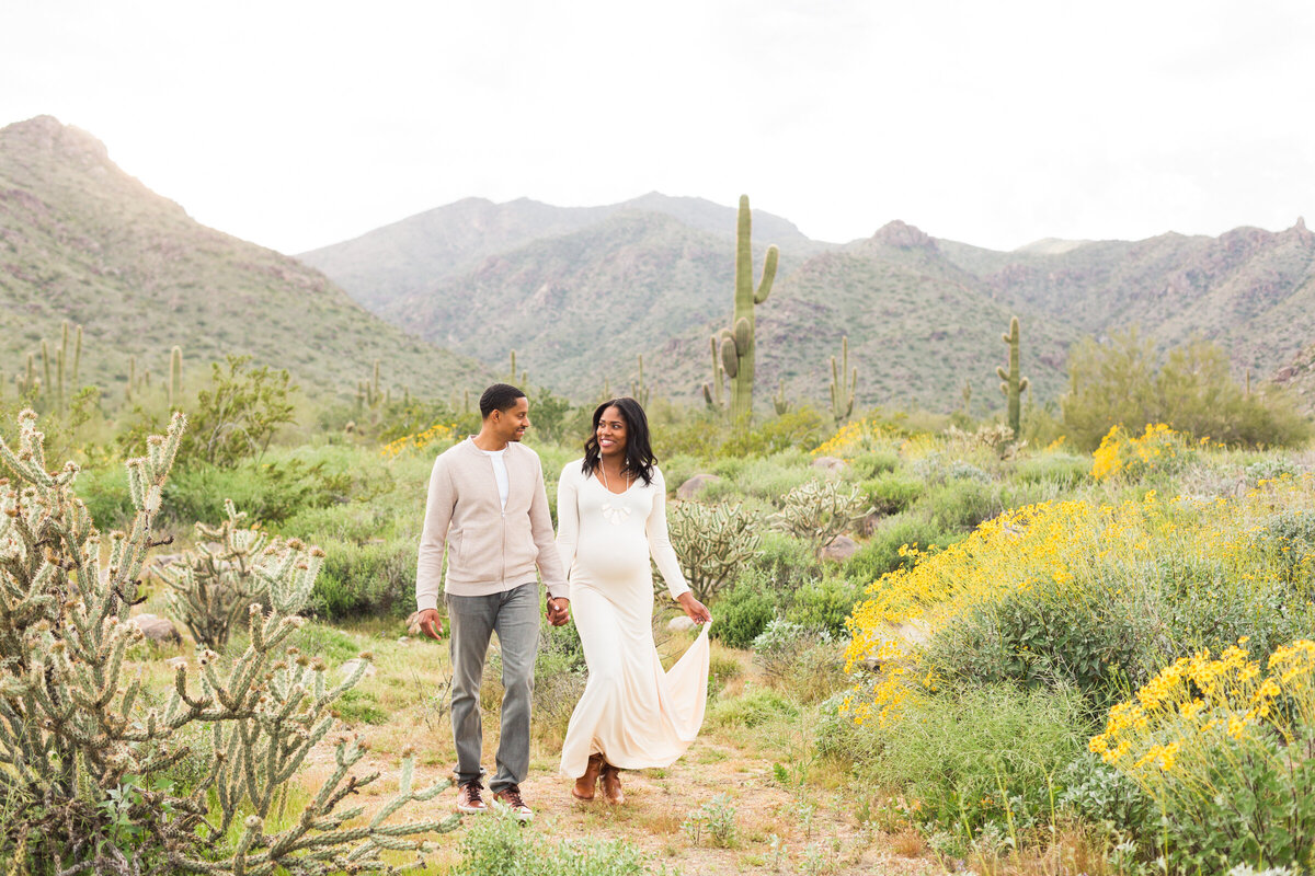 mom and dad to be posing for maternity photo in the desert