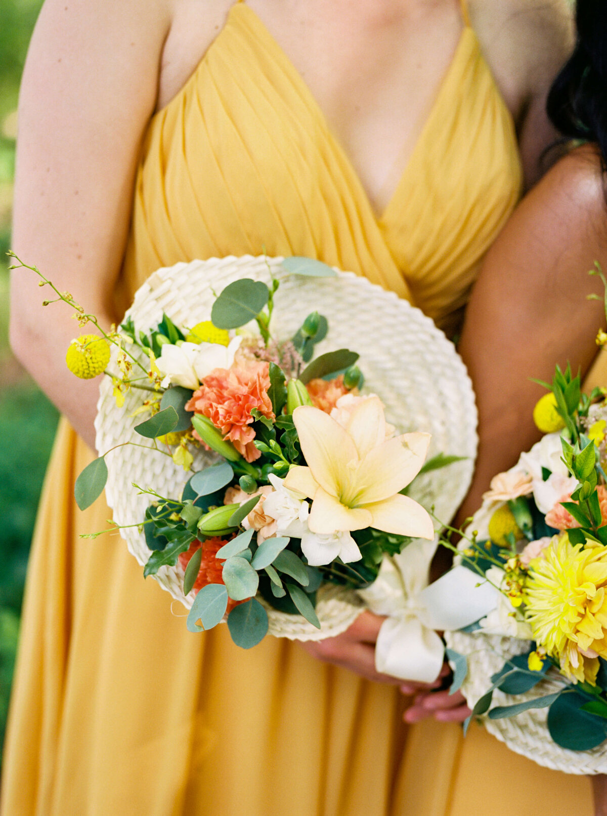 Bridesmaids wearing yellow dresses holding colorful bouquets