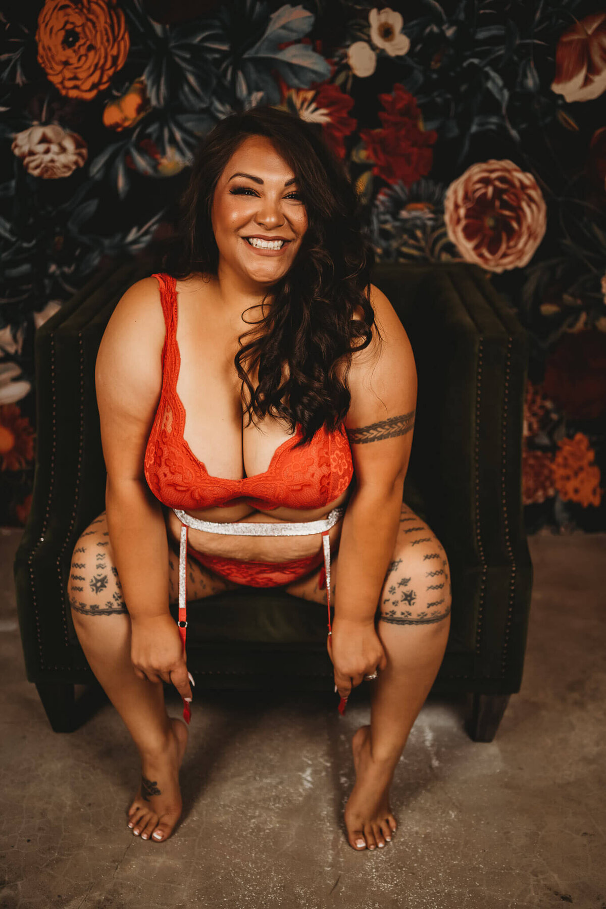 beautiful plus sized and tattooed woman wearing red lingerie, smiling at camera