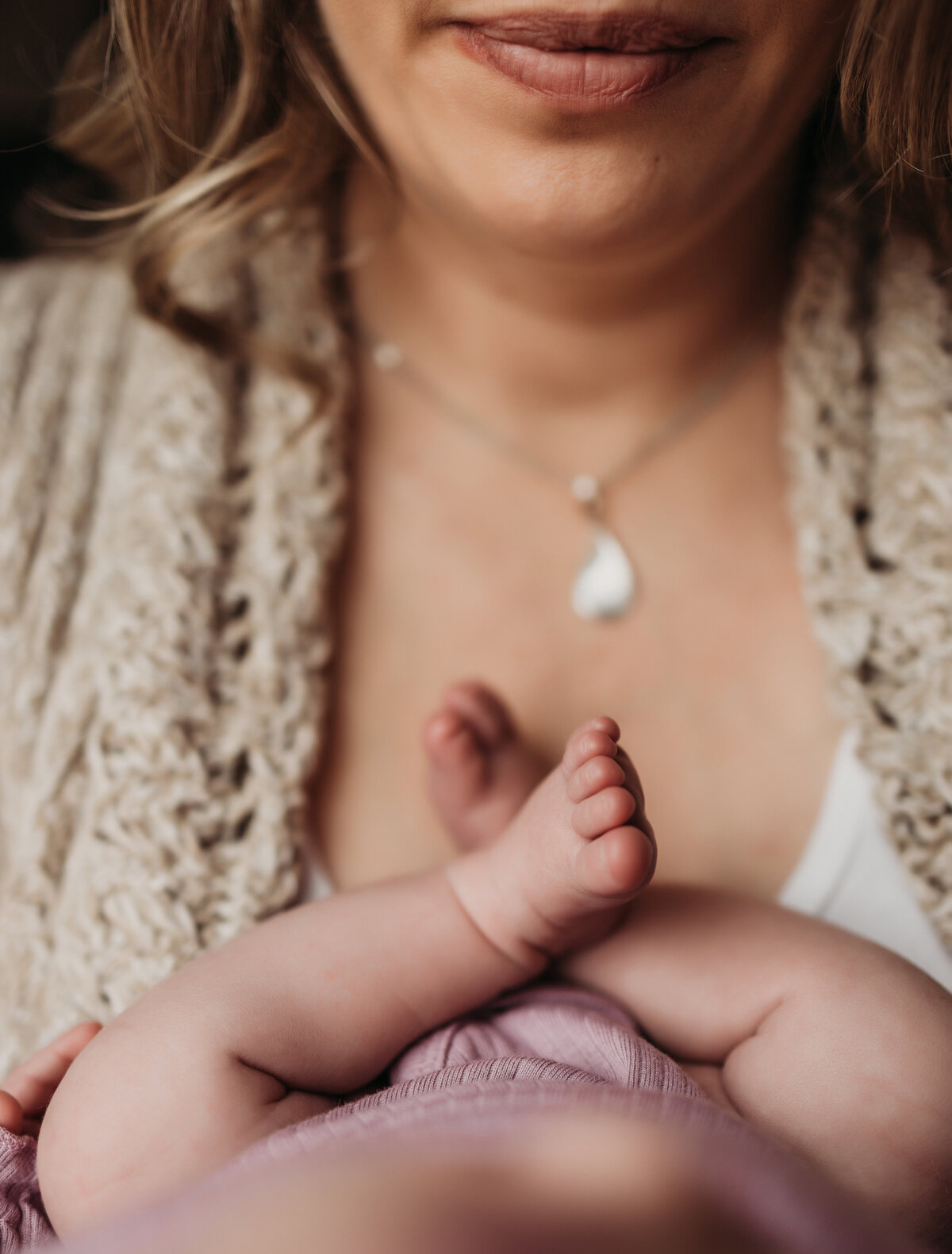 detail photo of newborn baby girls toes against moms chest