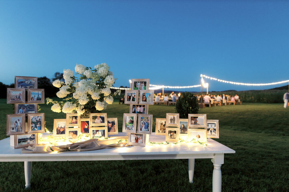 Photos of the bride and groom-to-be on picture frames are on a table outdoors at Lion Rock Farms, CT. Image by Jenny Fu Studio