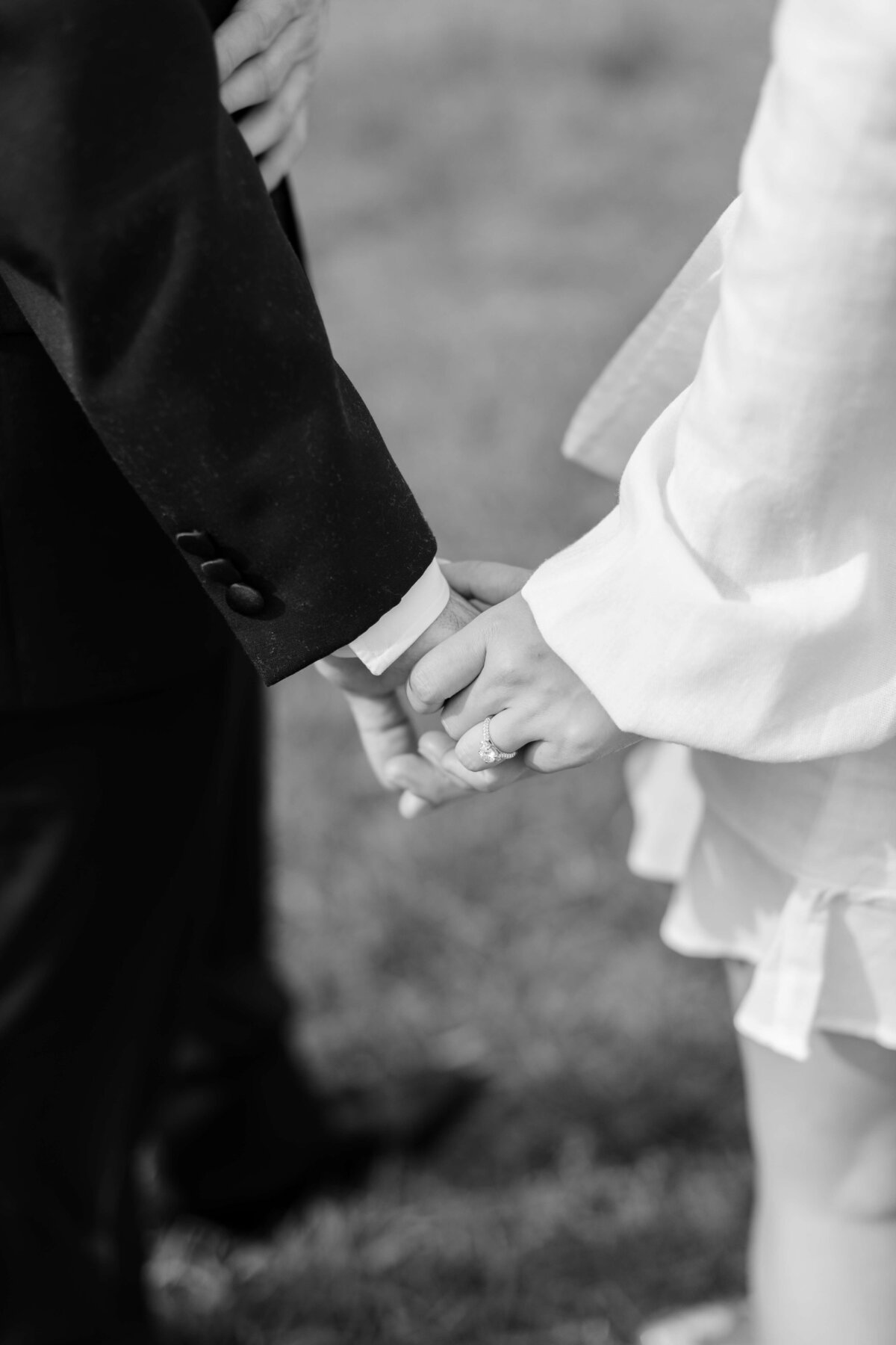 A bride and groom hold hands.
