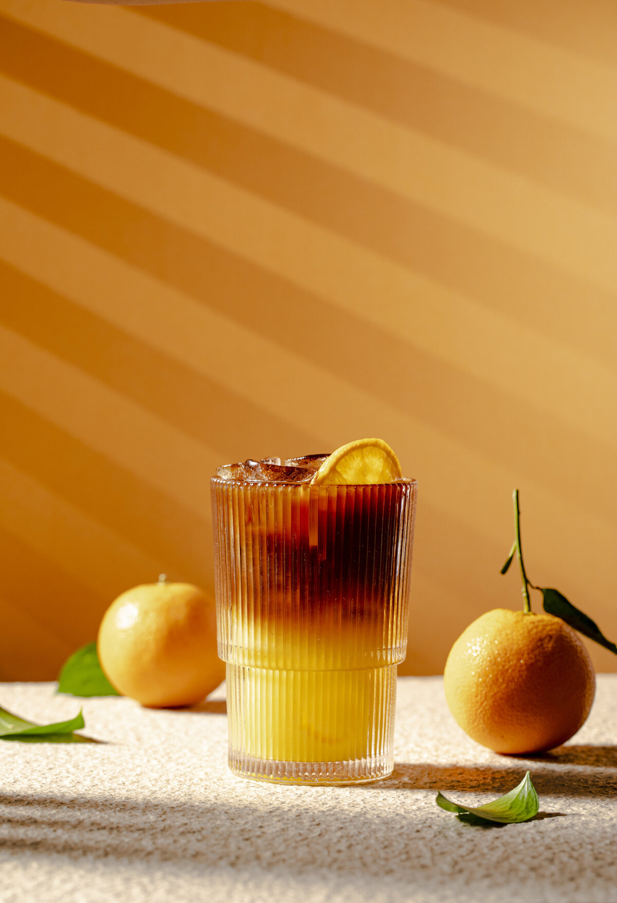 A layered orange drink in a short glass.