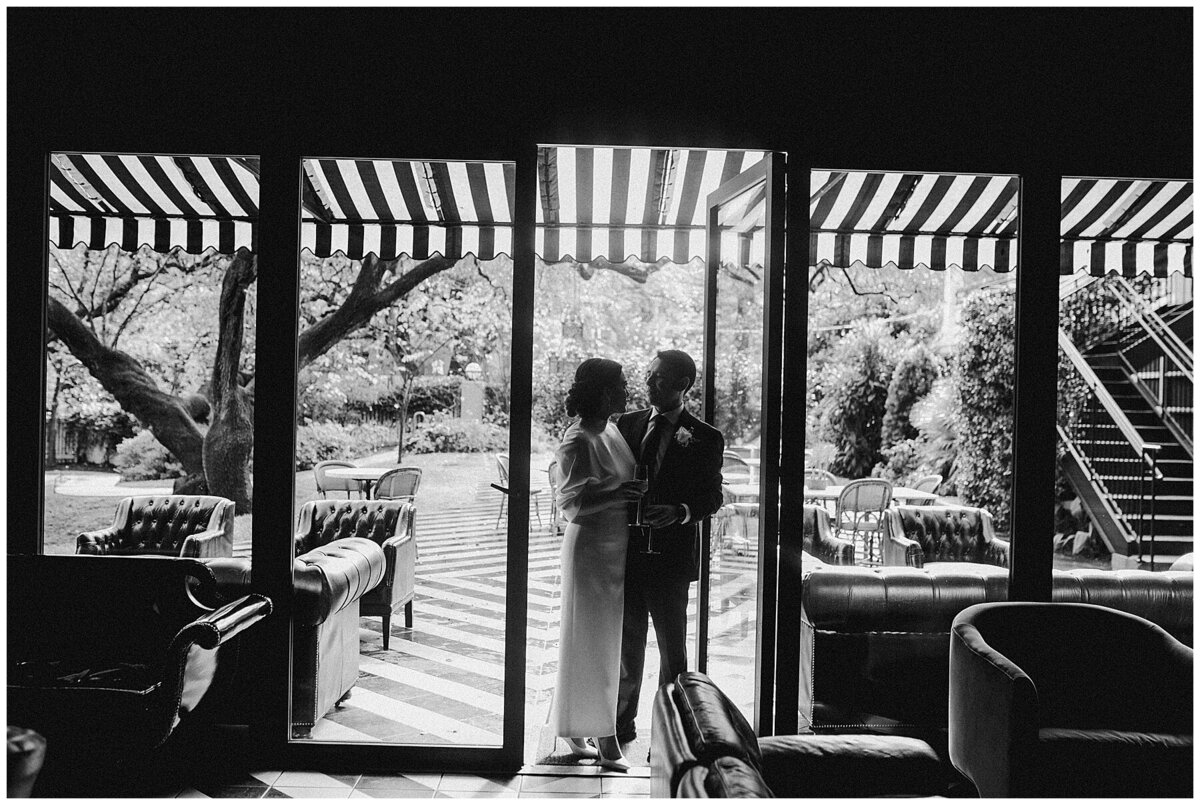 Bride and groom standing by doors at Hotel Saint Cecilia Austin