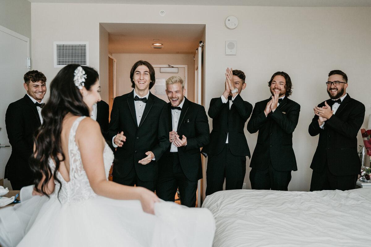 bride first look with groomsmen in tuxedos with bow ties