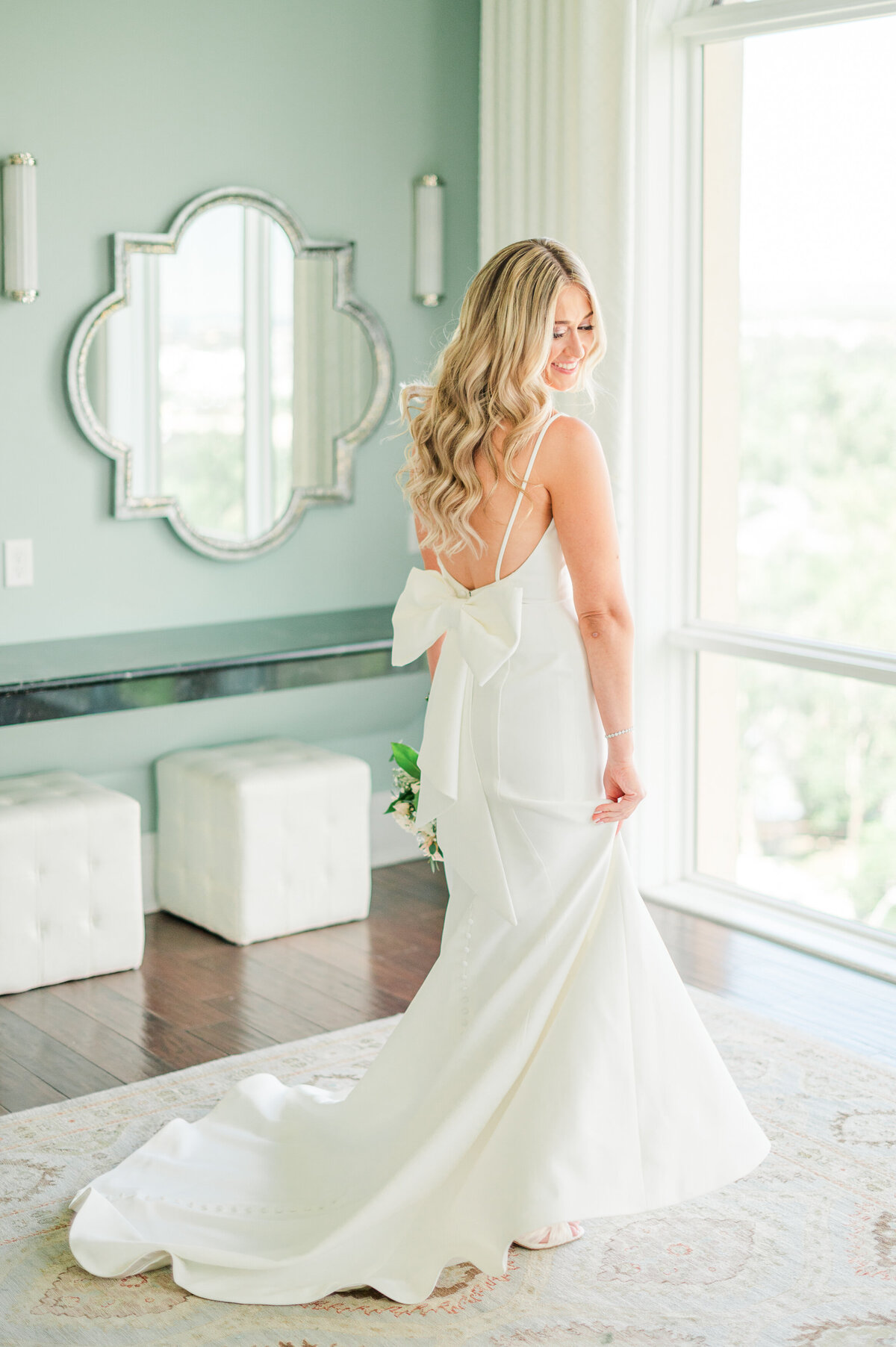 A blond bride showing off her wedding dress in the bridal suite at the Pinery at the Hill.