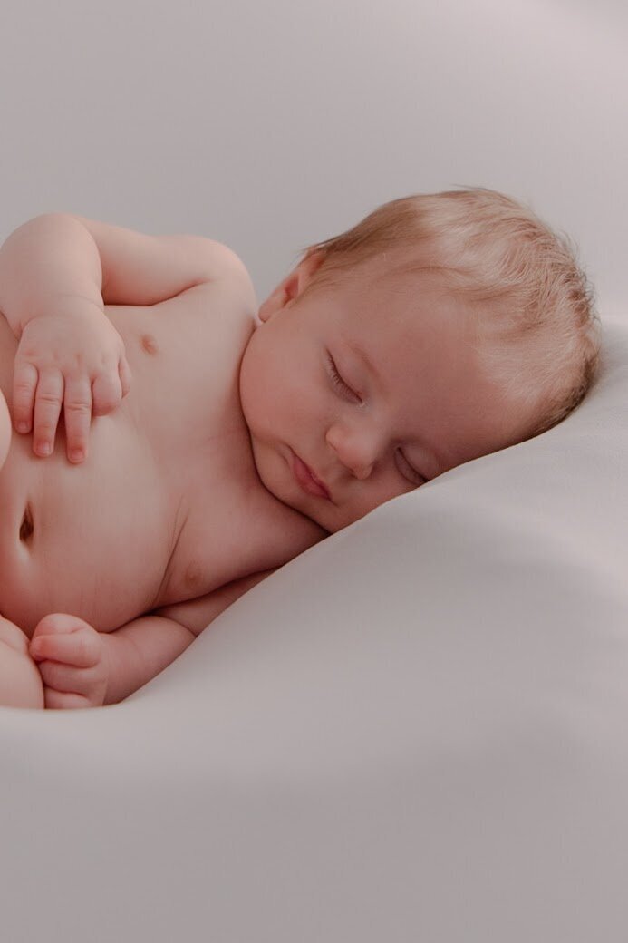 Greyson catching a nap between newborn baby photoshoots