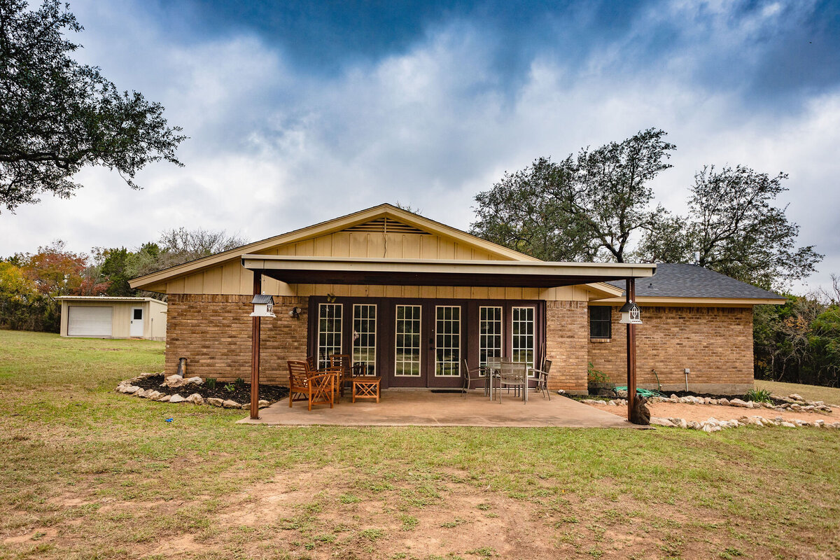Outdoor patio with seating and large yard area at this three-bedroom, two-bathroom ranch house for 7 with incredible hiking, wildlife and views.